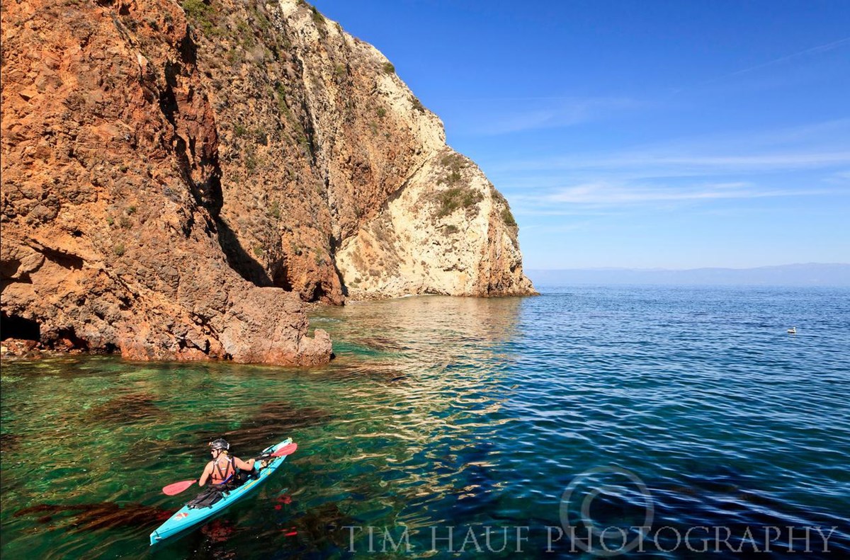 kayak on ocean near steep clifss