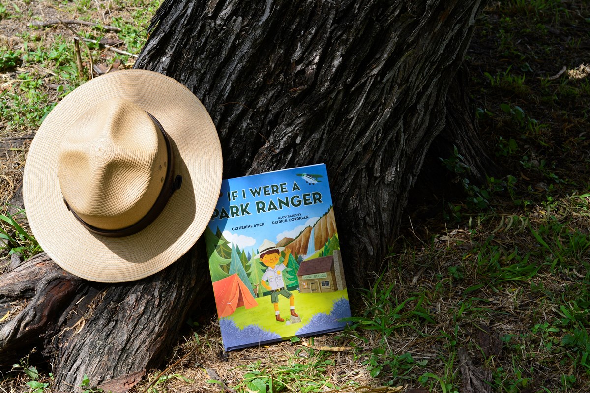 Book 'If I were a Park Ranger' leaned up against a mesquite tree, with flat hat nearby.