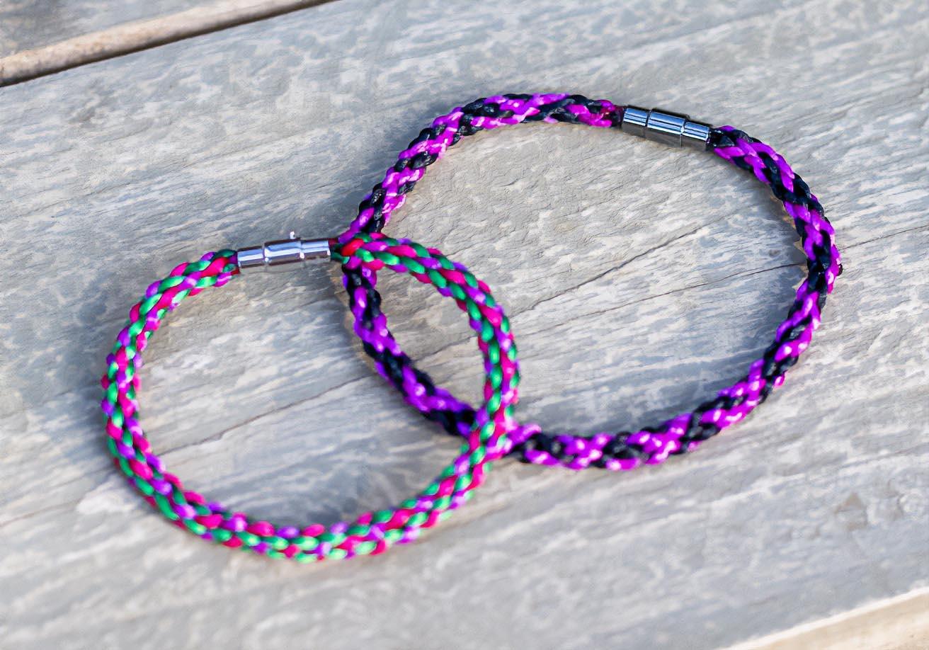 A braided bracelet smooth, rounded, and tightly woven cord made from multiple purple strands