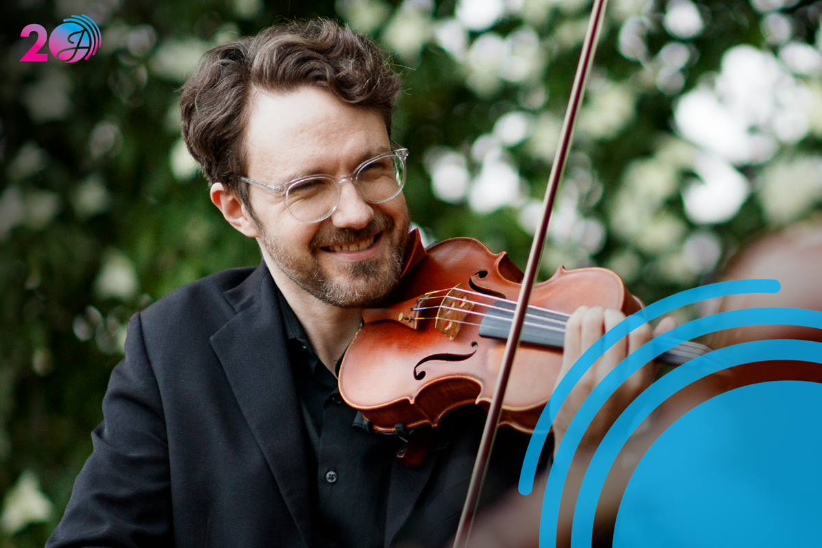 Man playing a violin outdoors.