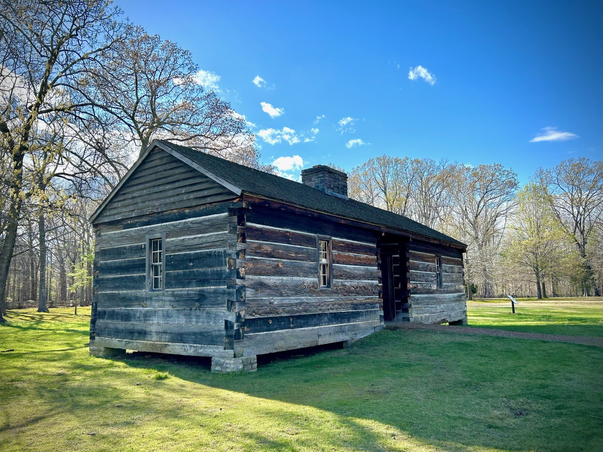 A small wooden cabin with a gravel trail.