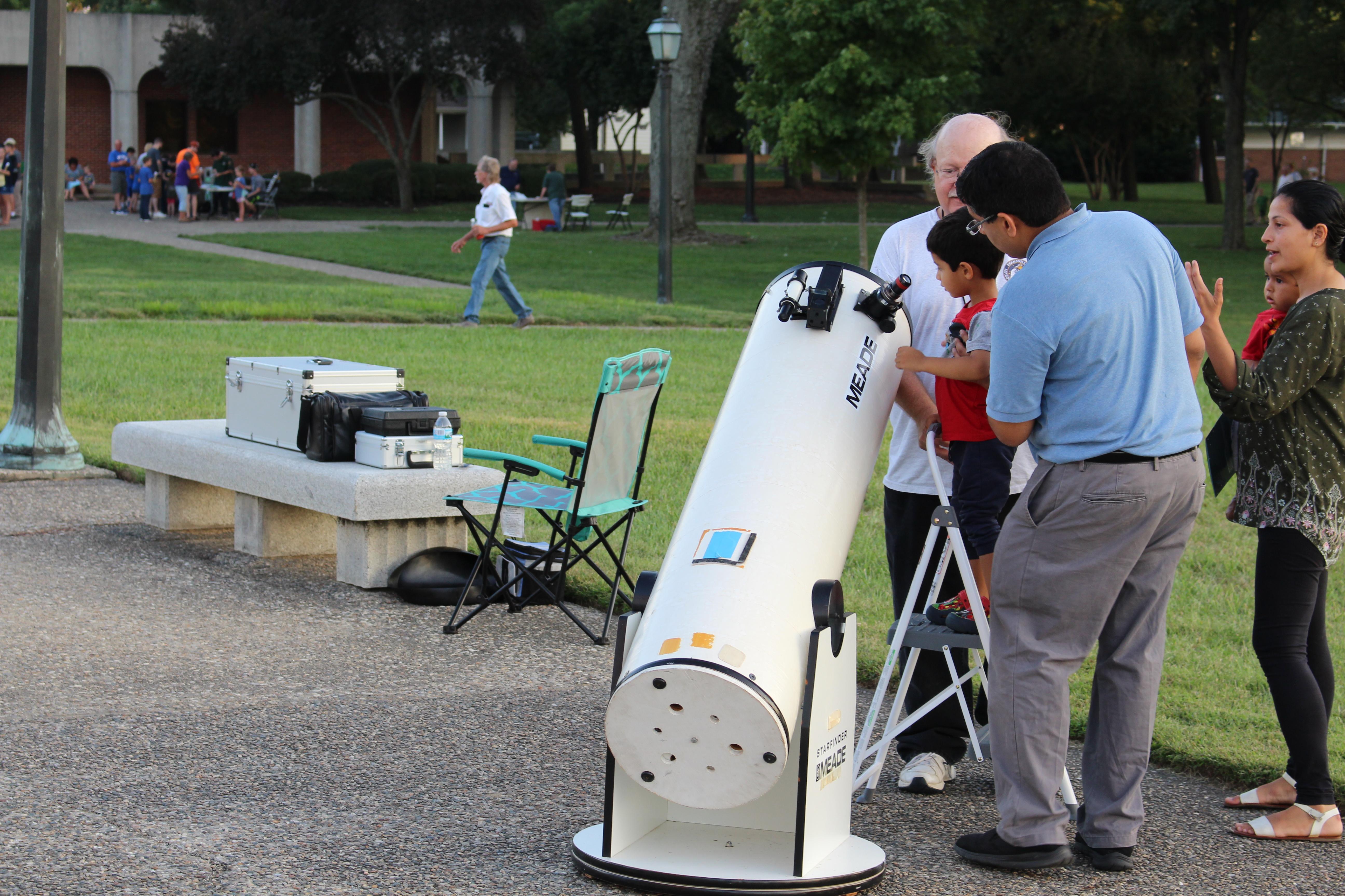 Several people looking through a telescope