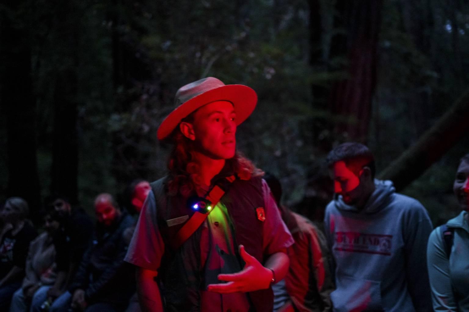 a ranger in a red light speaks to visitors
