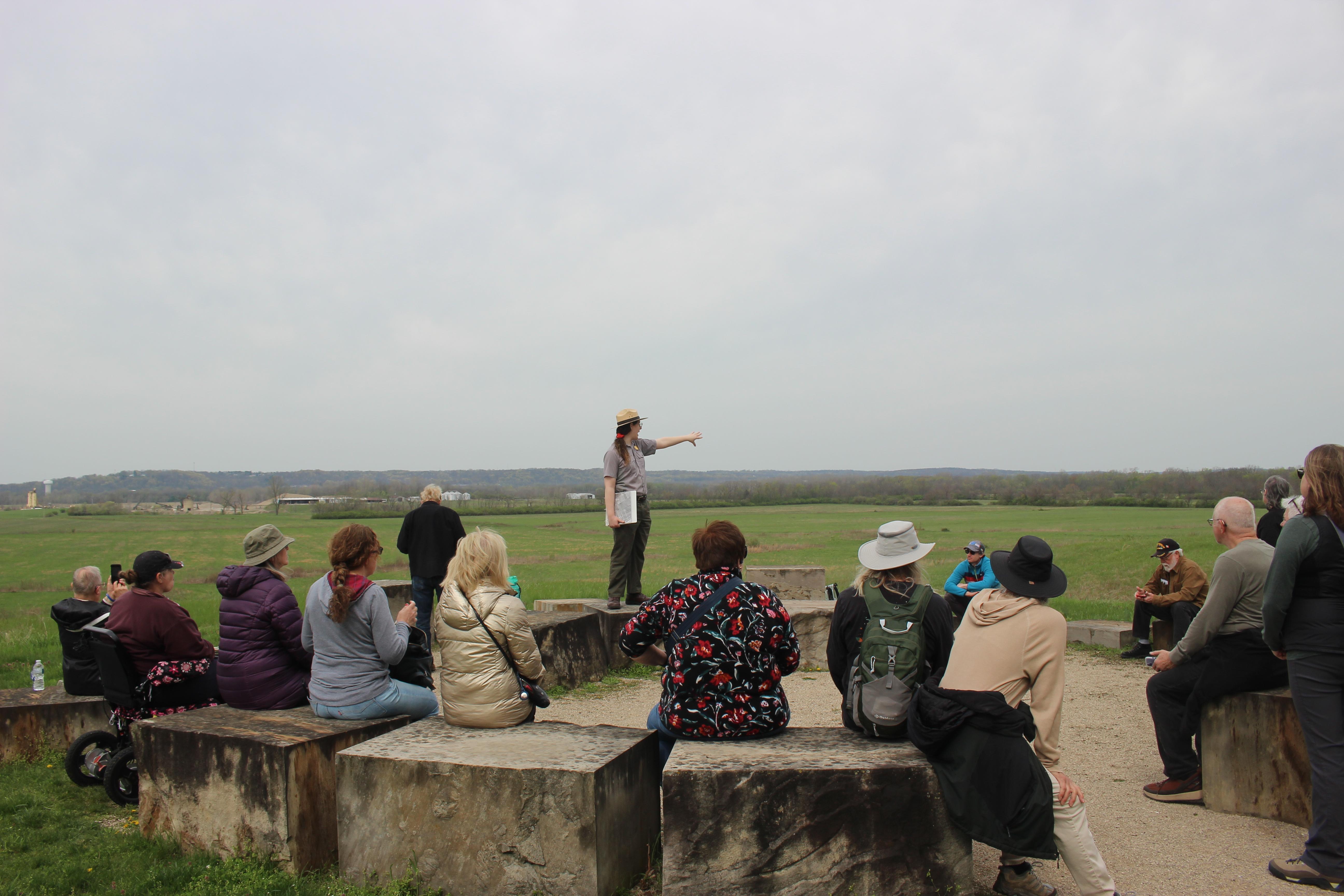 a ranger speaks to a  large group of people at an outdoor event.