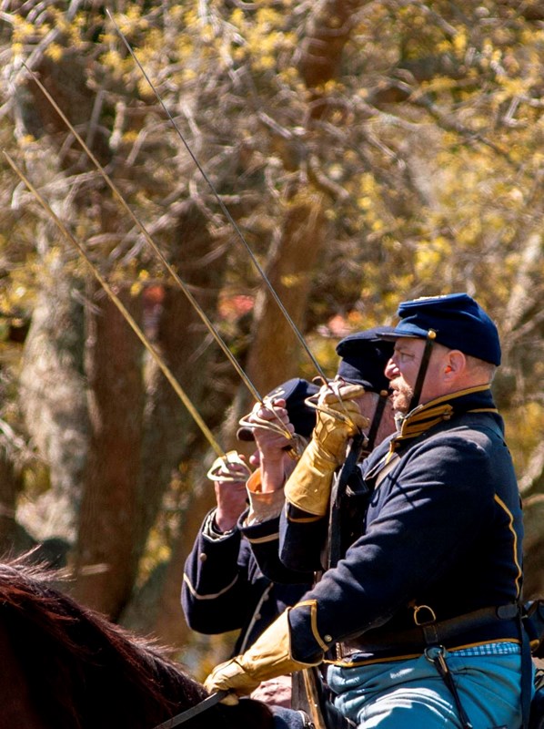 Mounted American Civil War US Cavalry soldiers in a line salute with their swords.