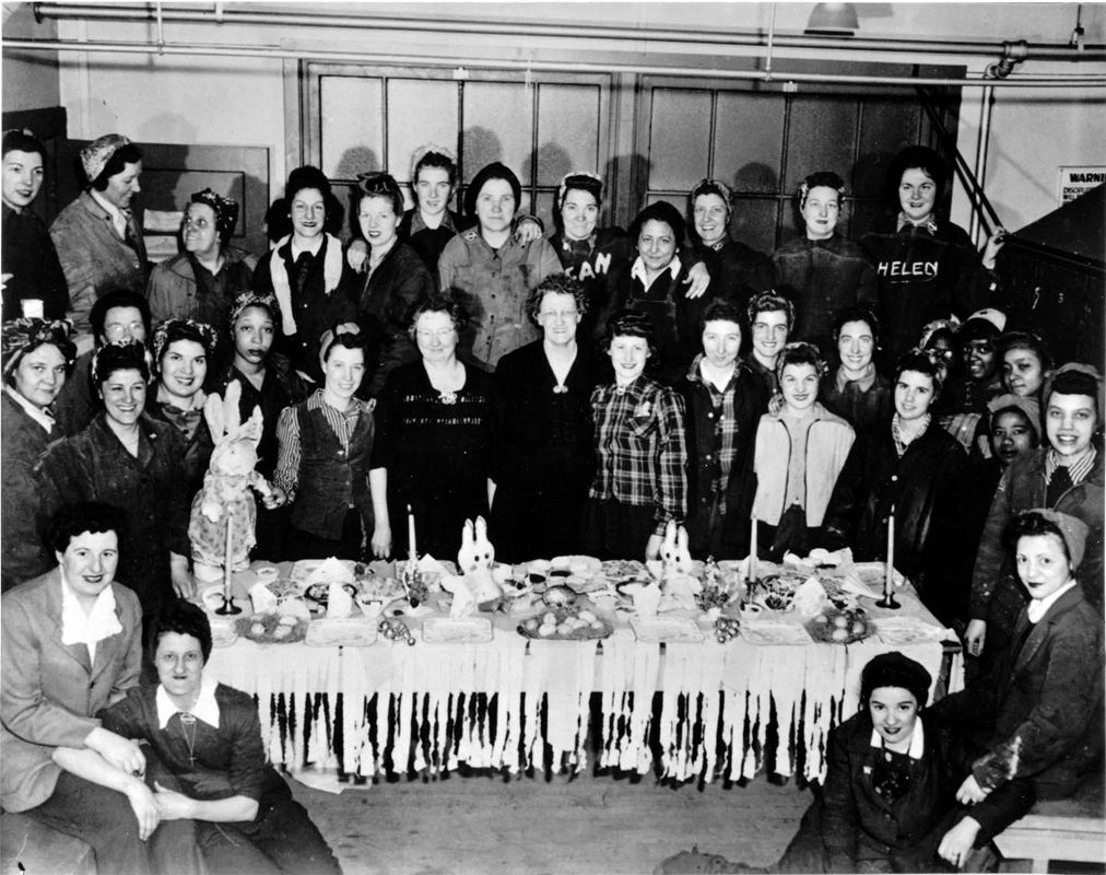 A photograph of women Navy Yard workers sitting around a celebratory table spread.
