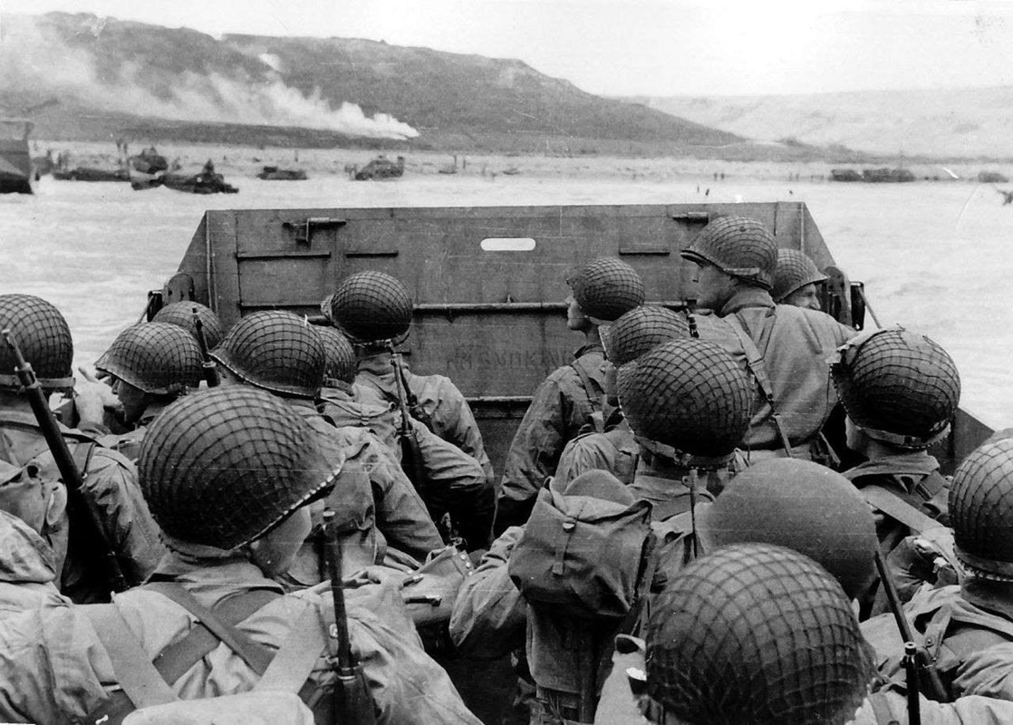 A black and white image showing US soldiers aboard a landing craft heading to Omaha Beach
