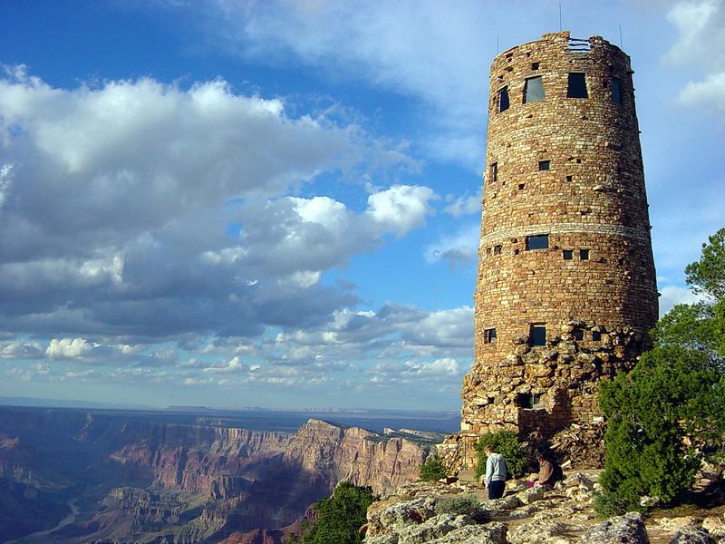 A tall structure made of stone on the edge of the canyon