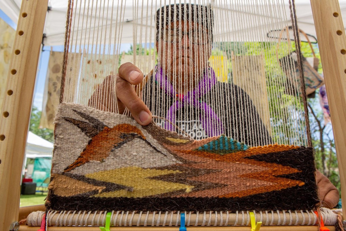 A Navajo demonstrator weaving a pattern.