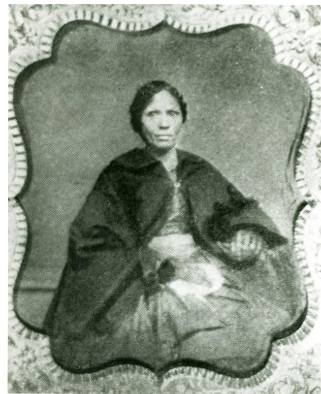 A photograph of the lady sitting with a black shawl.