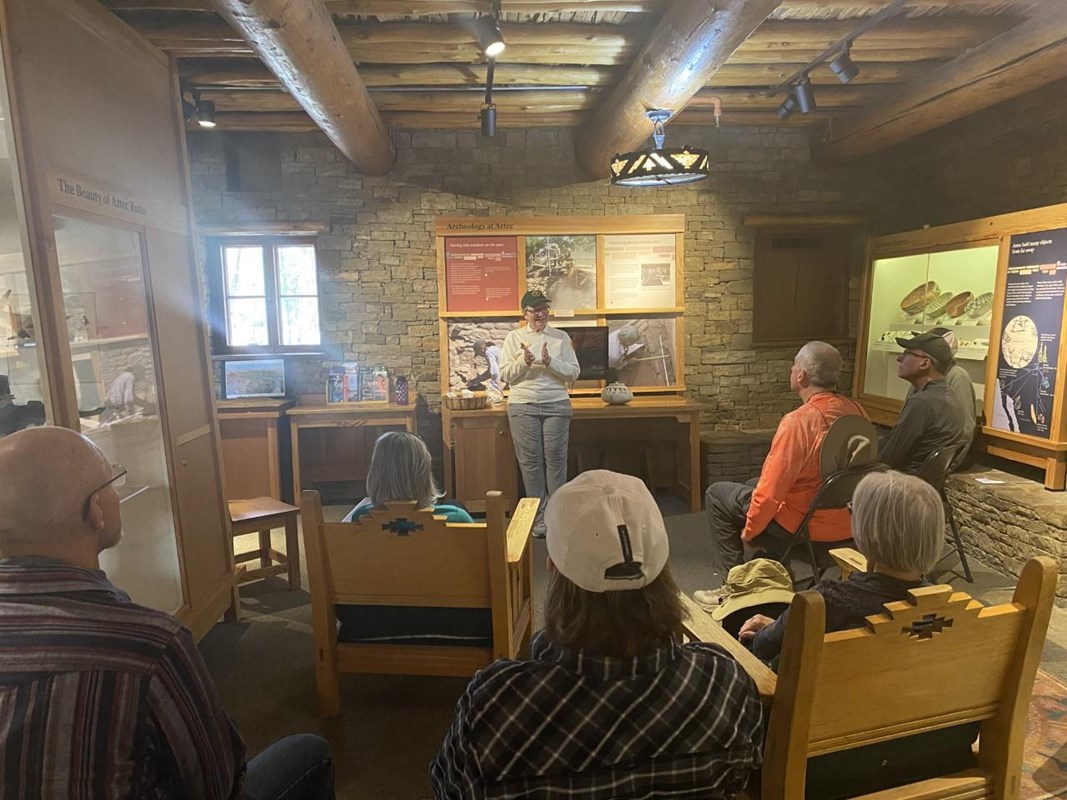 A park volunteer giving a talk to a group of visitors inside the visitor center.