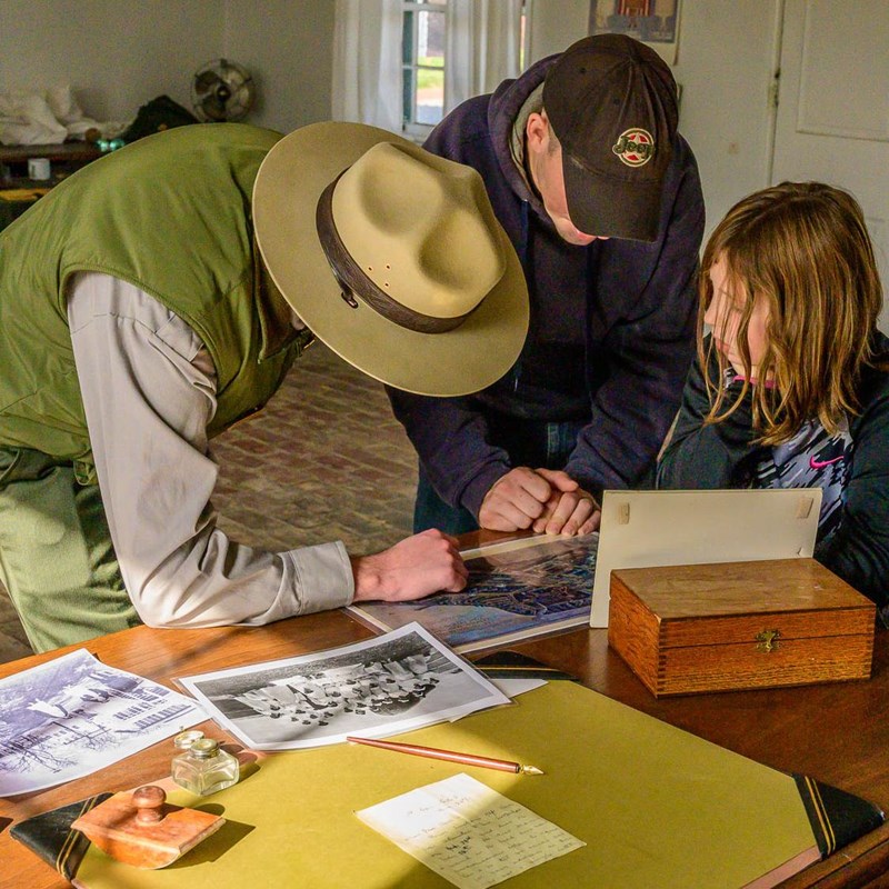 Park Ranger speaking with visitors about World War I images at Fort McHenry