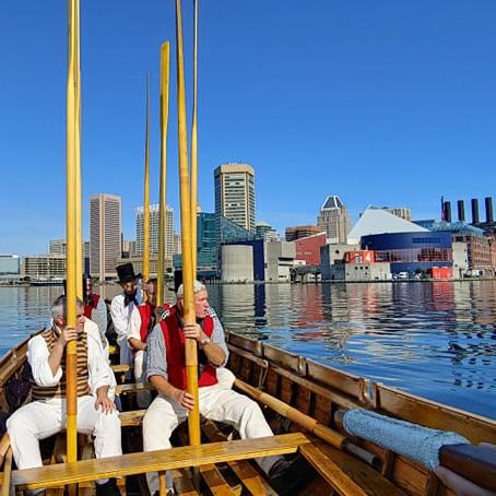 Living history sailors with oars with Baltimore skyline in background