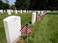 Small American Flags stand in front of headstones in the Gettysburg National Cemetery