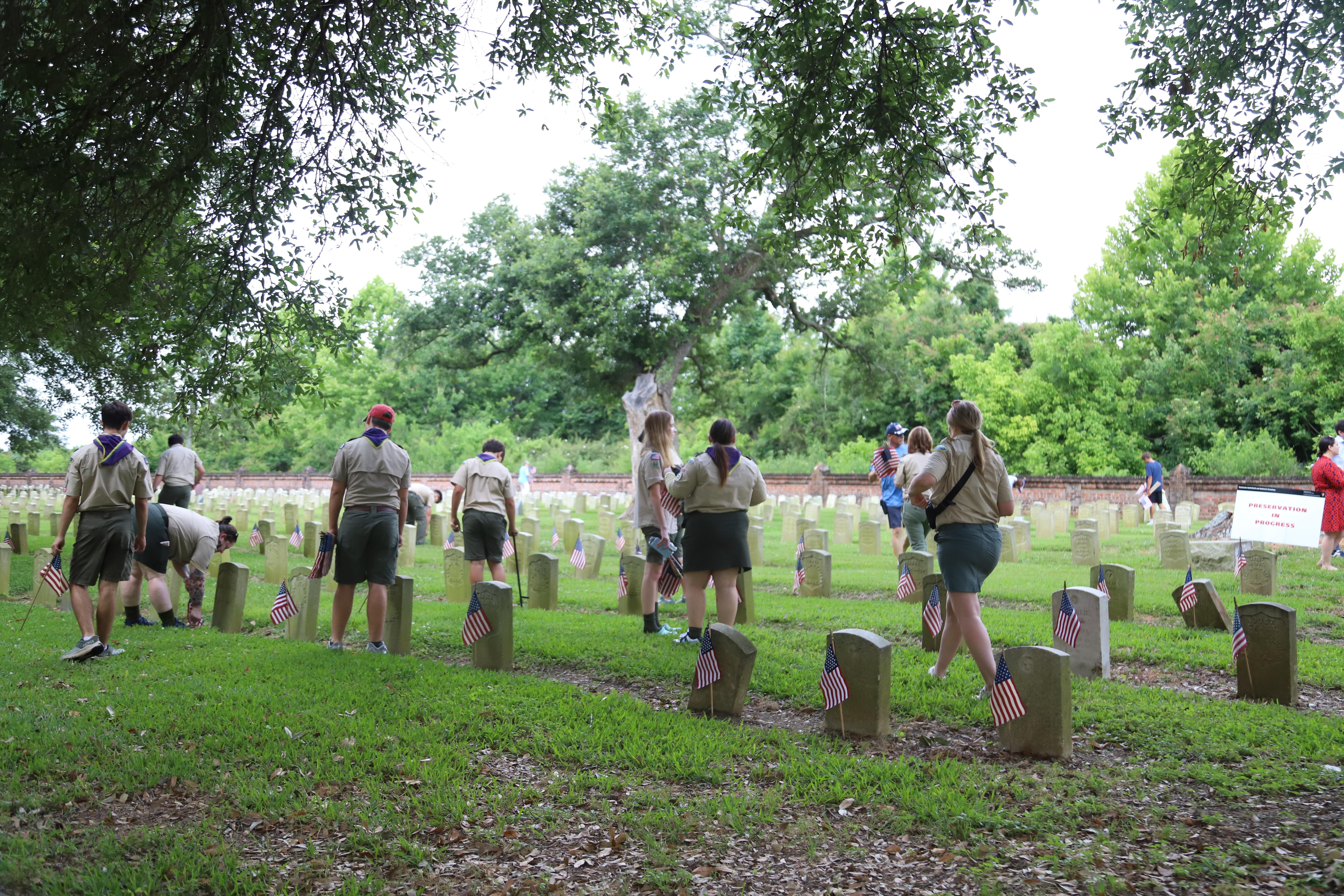 A group of scouts placing flags.