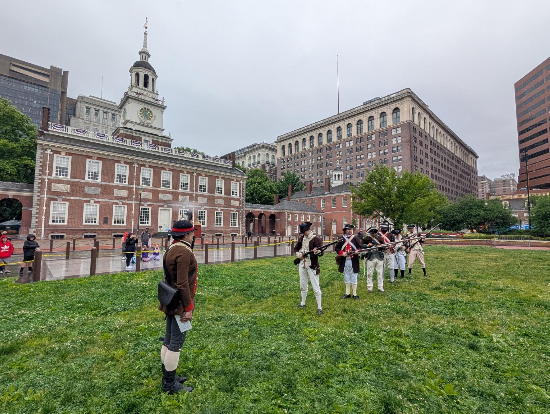 soldiers stand on green in front of large building
