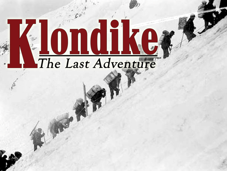 A line of prospectors with large backpacks climb up the side of a steep, snowy mountain.