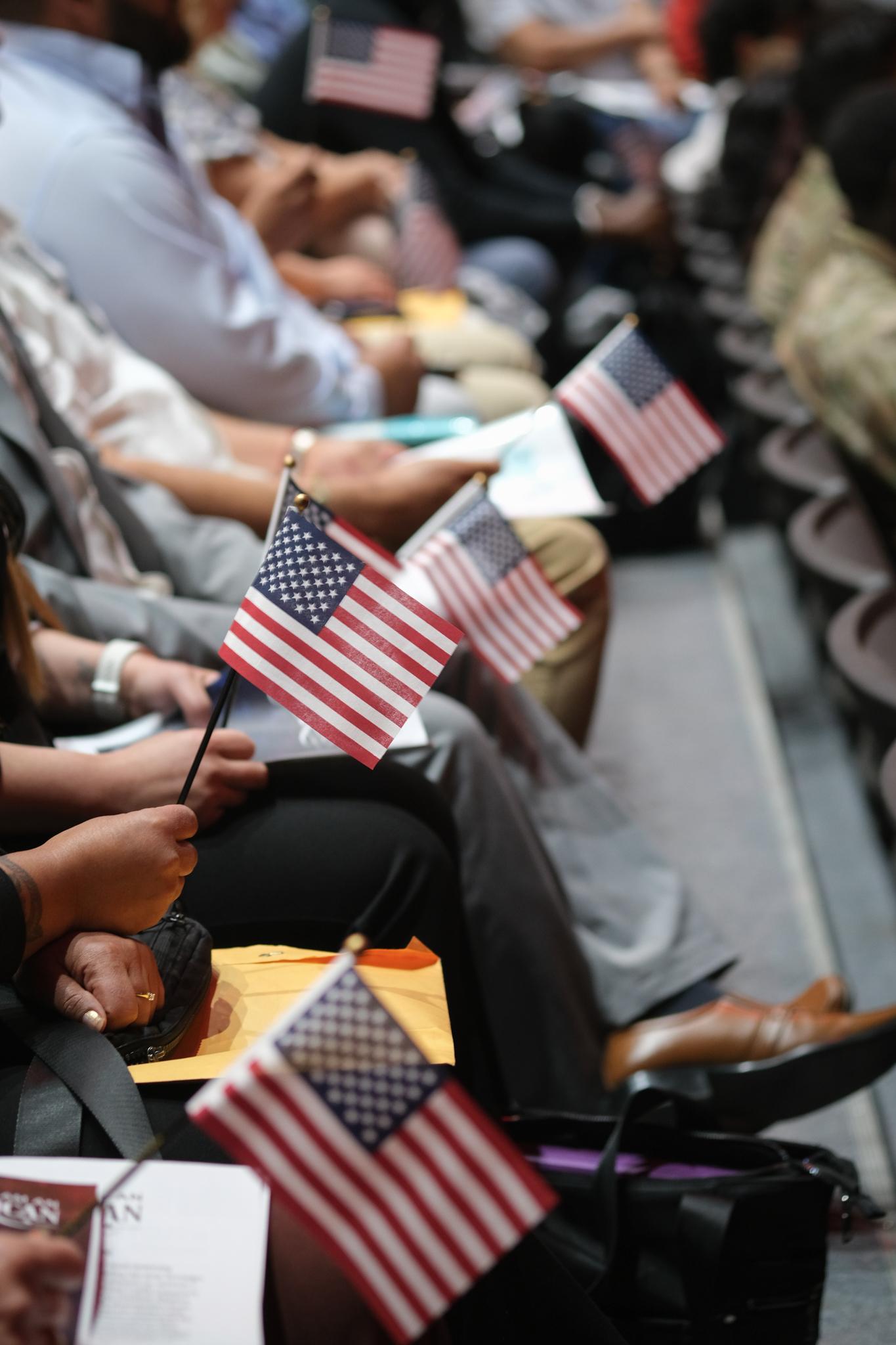 A row of audience members holding miniature U.S. flags.