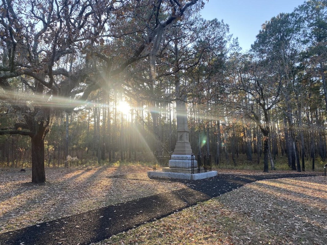 The patriot monument on a fall afternoon with the sun shining through the pine trees