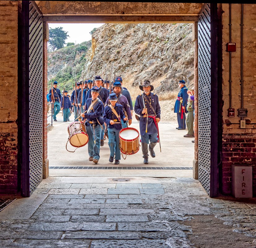 Civil War era reenactors with fife and drums march through the sallyport at Fort Point NHS