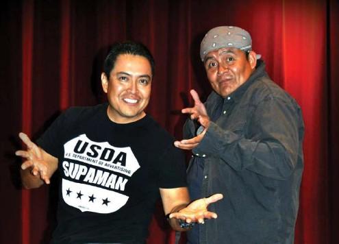 Two men smile and stand with their hands outstretched