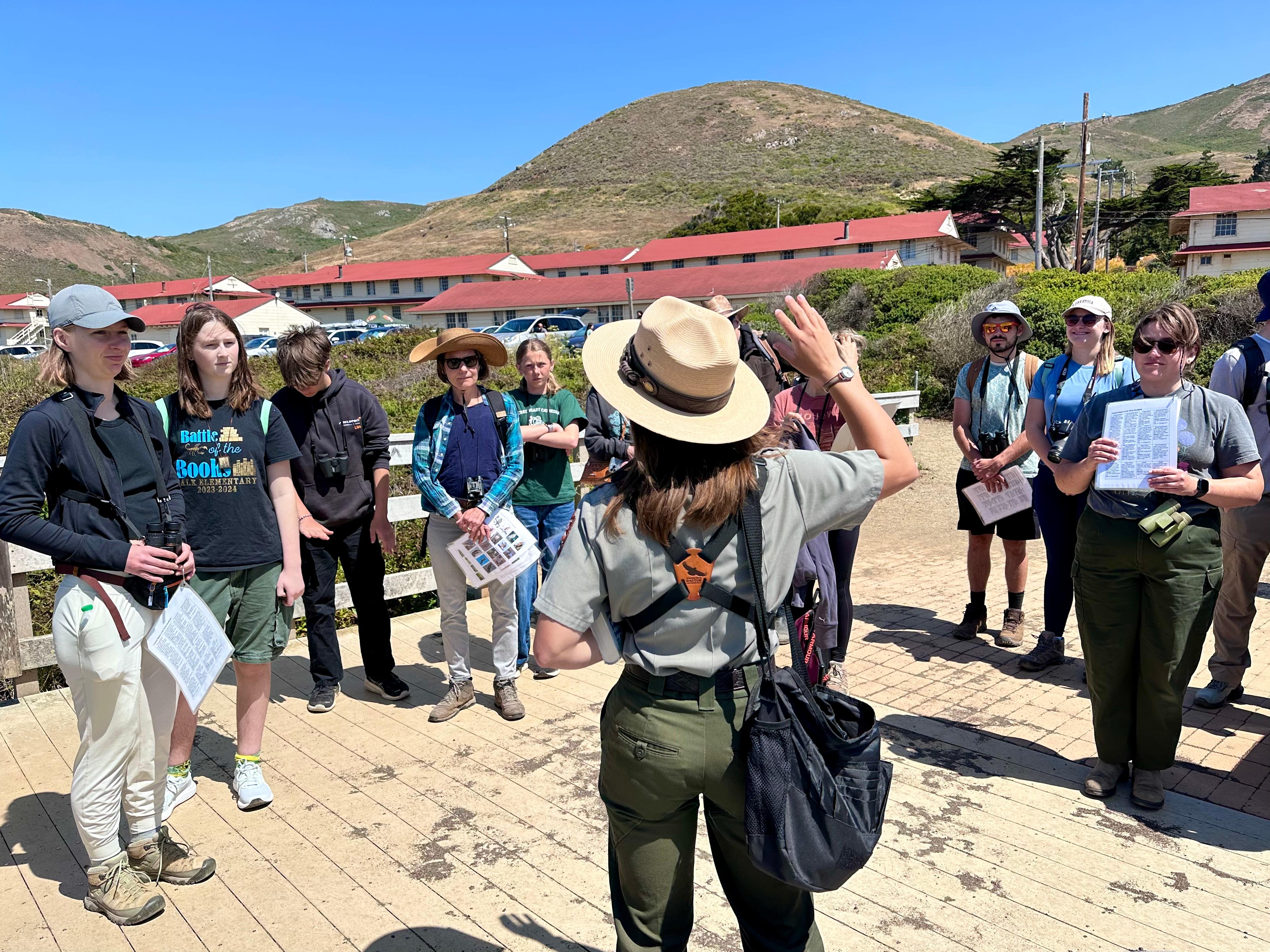 ranger stands and talks with visitors facing her
