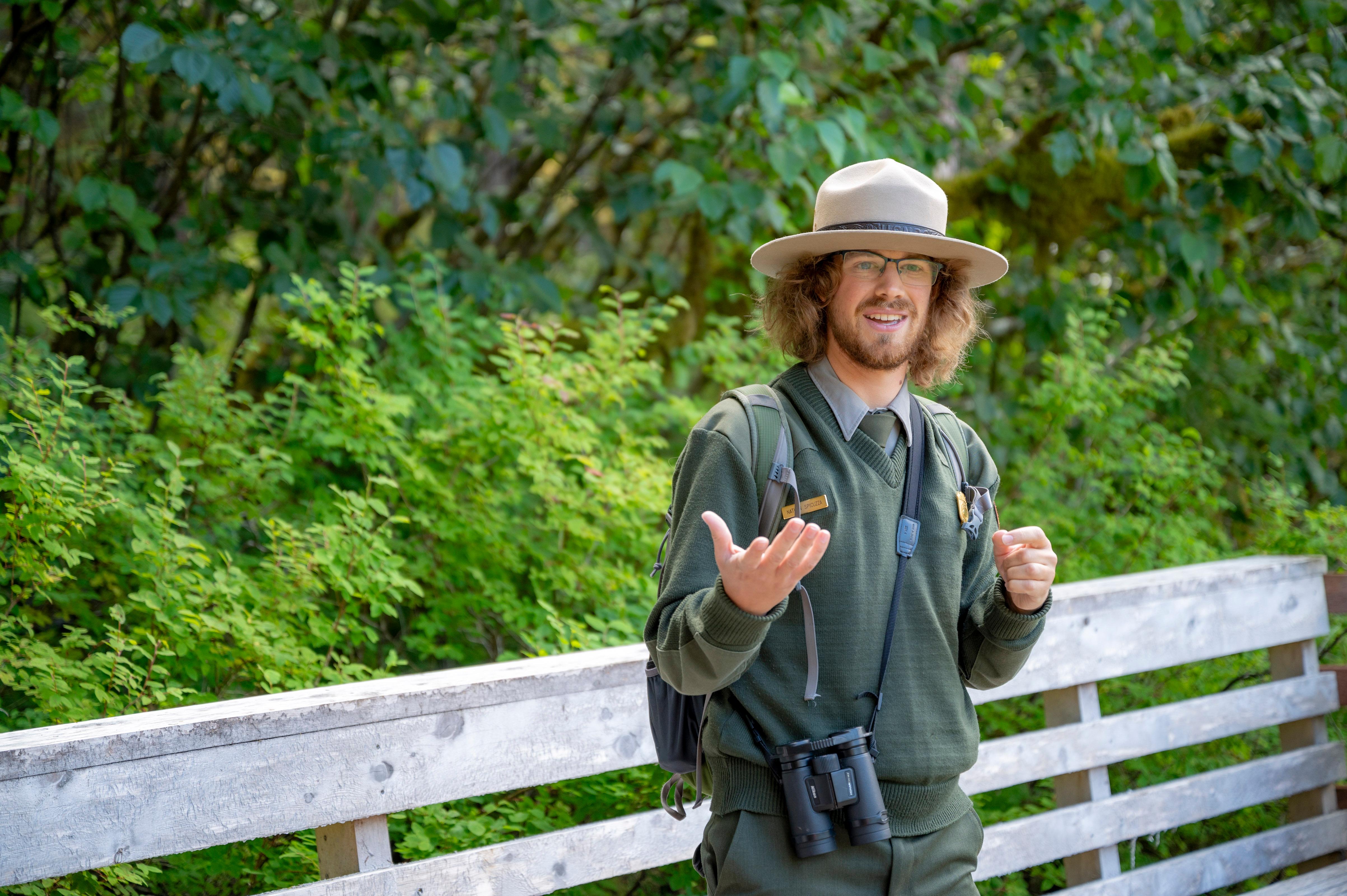 Park Ranger Nate gesticulates while speaking to guests on a walk.
