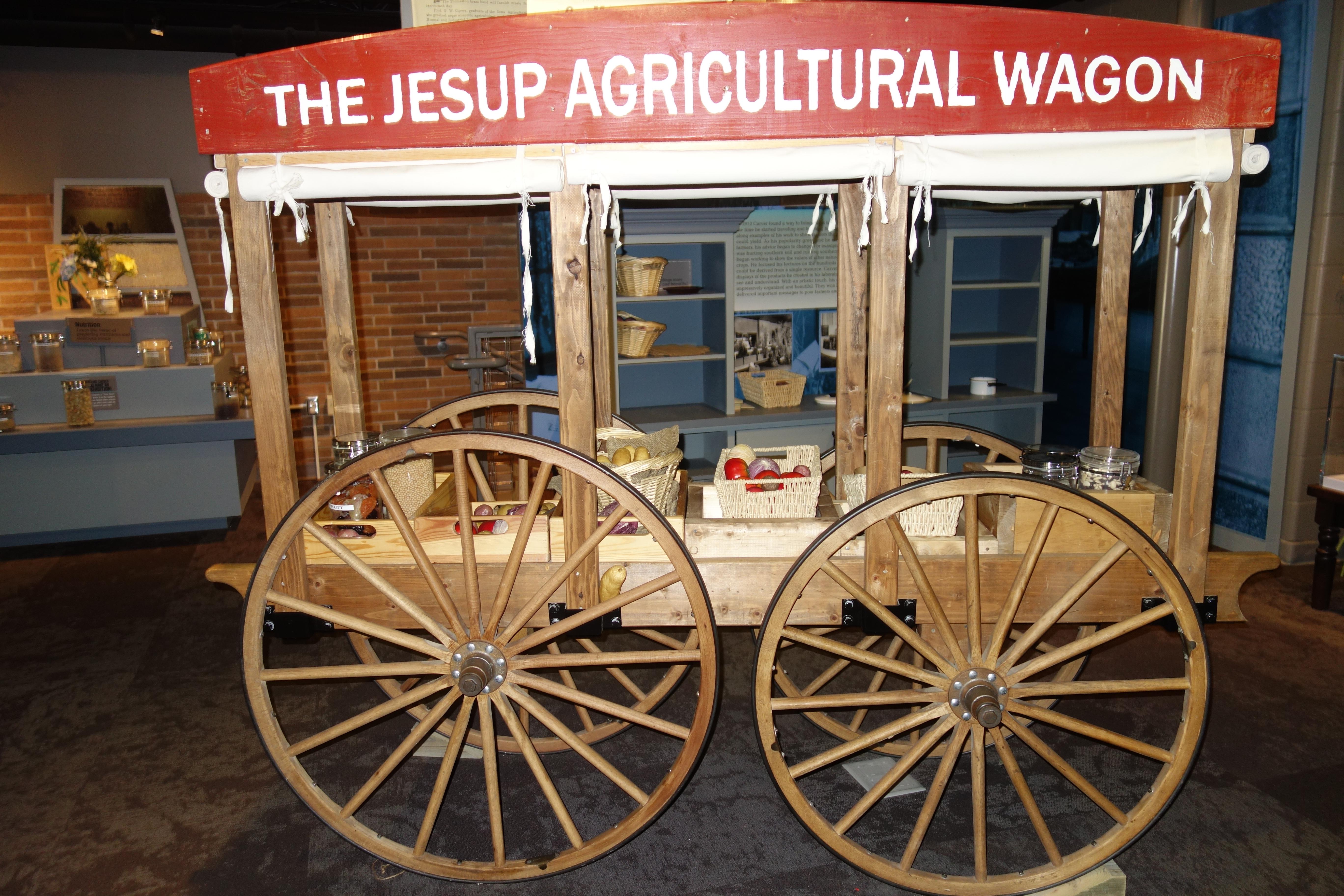 A wagon with large wood wheels with food items.