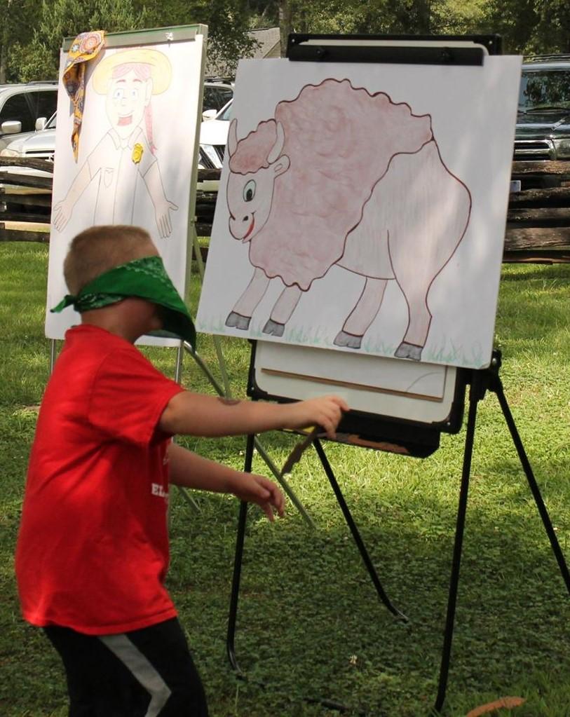 A young boy plays pin the tail on the bison.