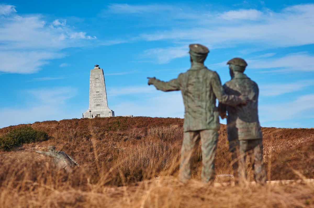 Statue of Wright Brothers looking towards monument