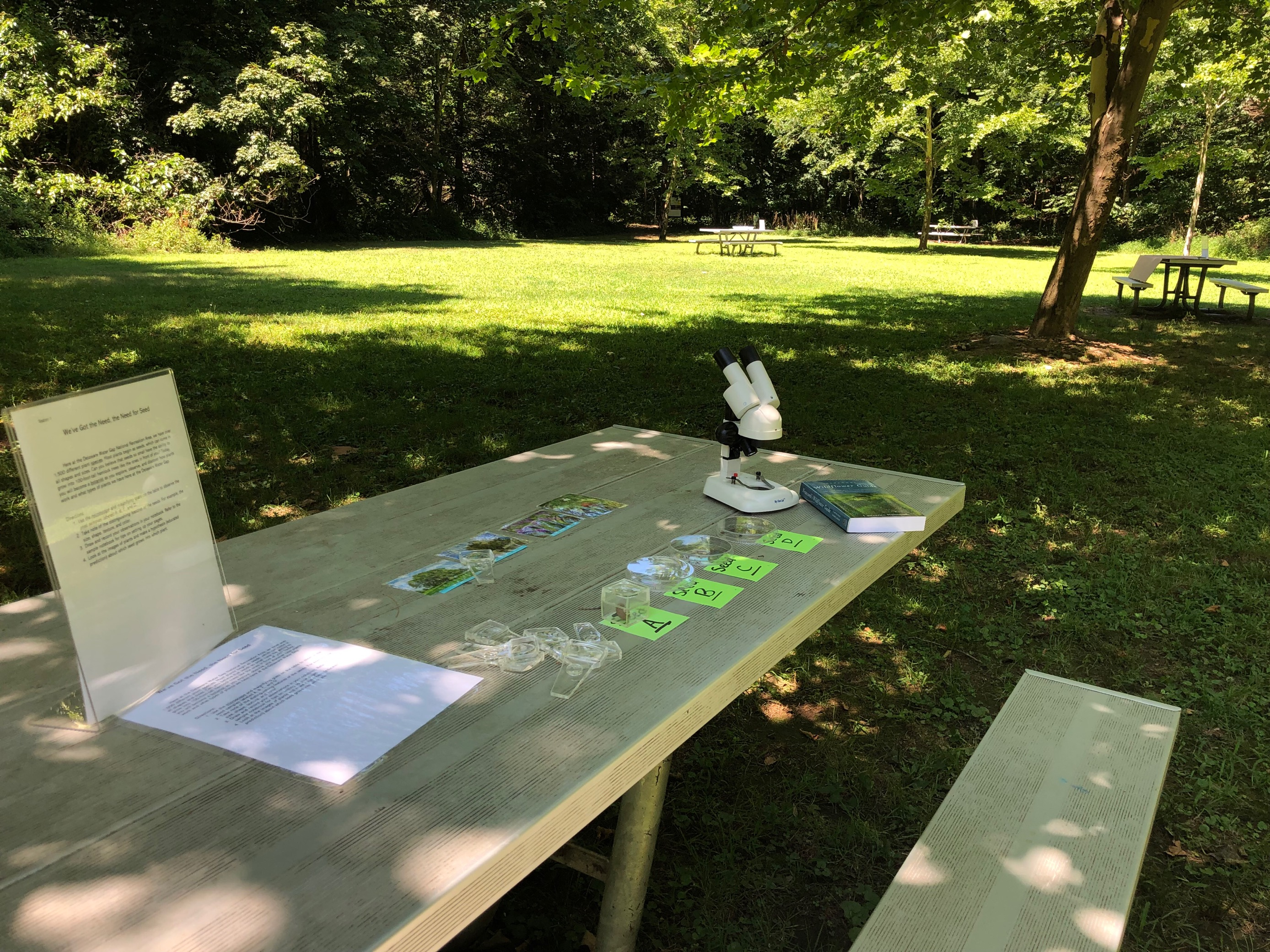 A picnic table with a telescope and other objects on it.