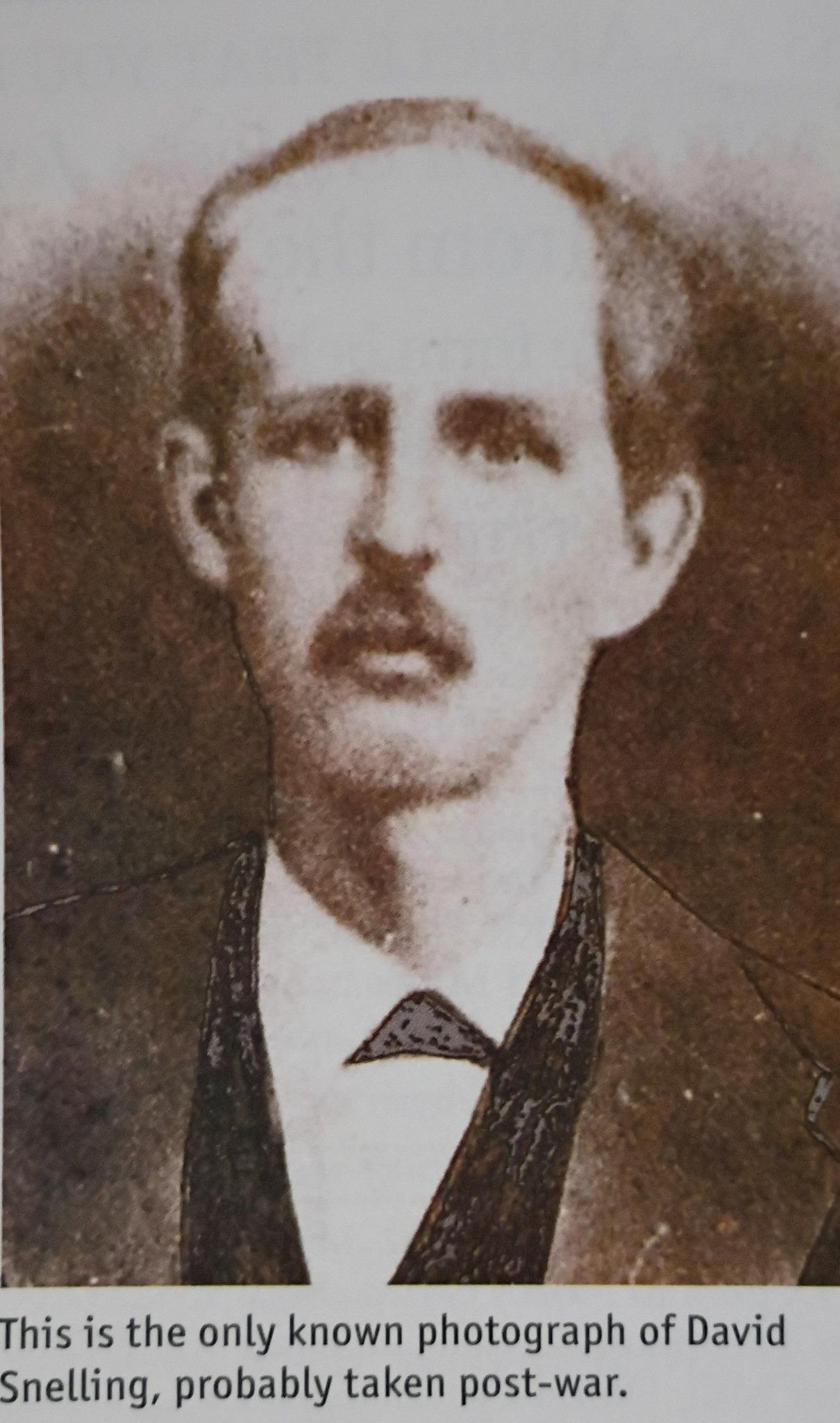 Image of a man with a mustache wearing a suit