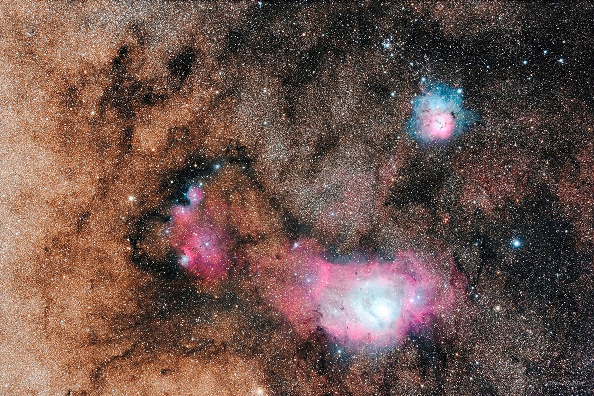 An image of deep space showing large colorful clouds of gas and dust