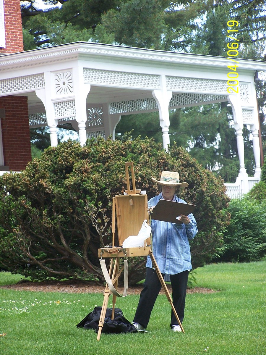 Artist and easel in front of Mansion