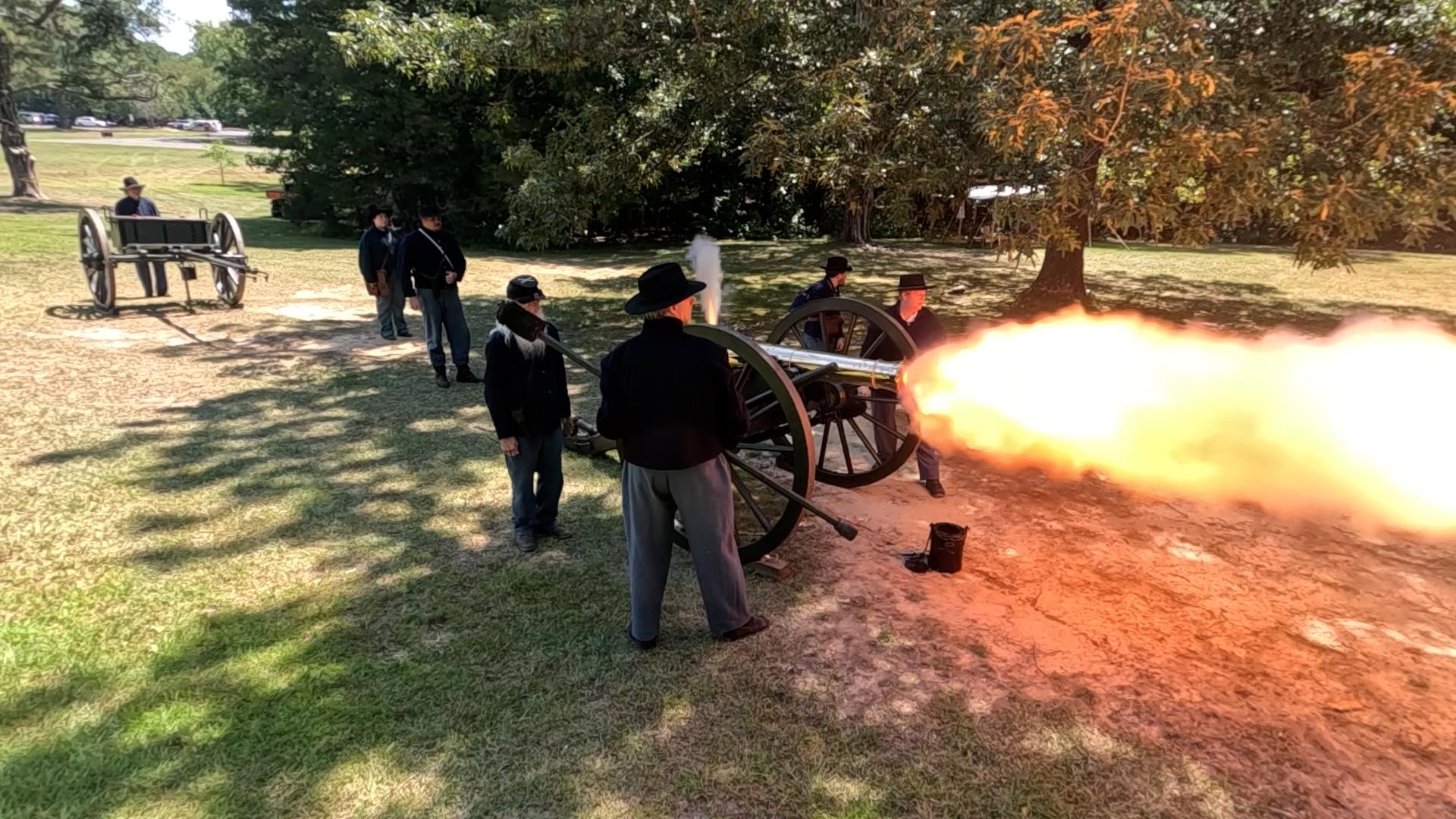 Living historians fire a bronze cannon.