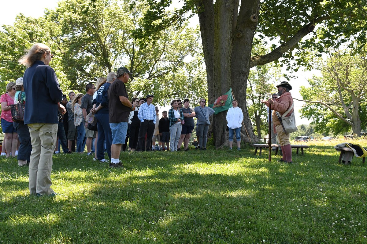 a crowd gathers under a tree