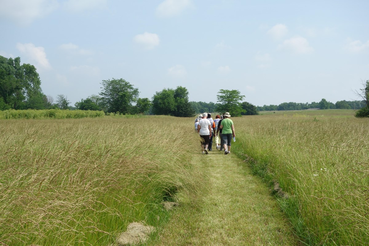 Visitors walking through a prairie.