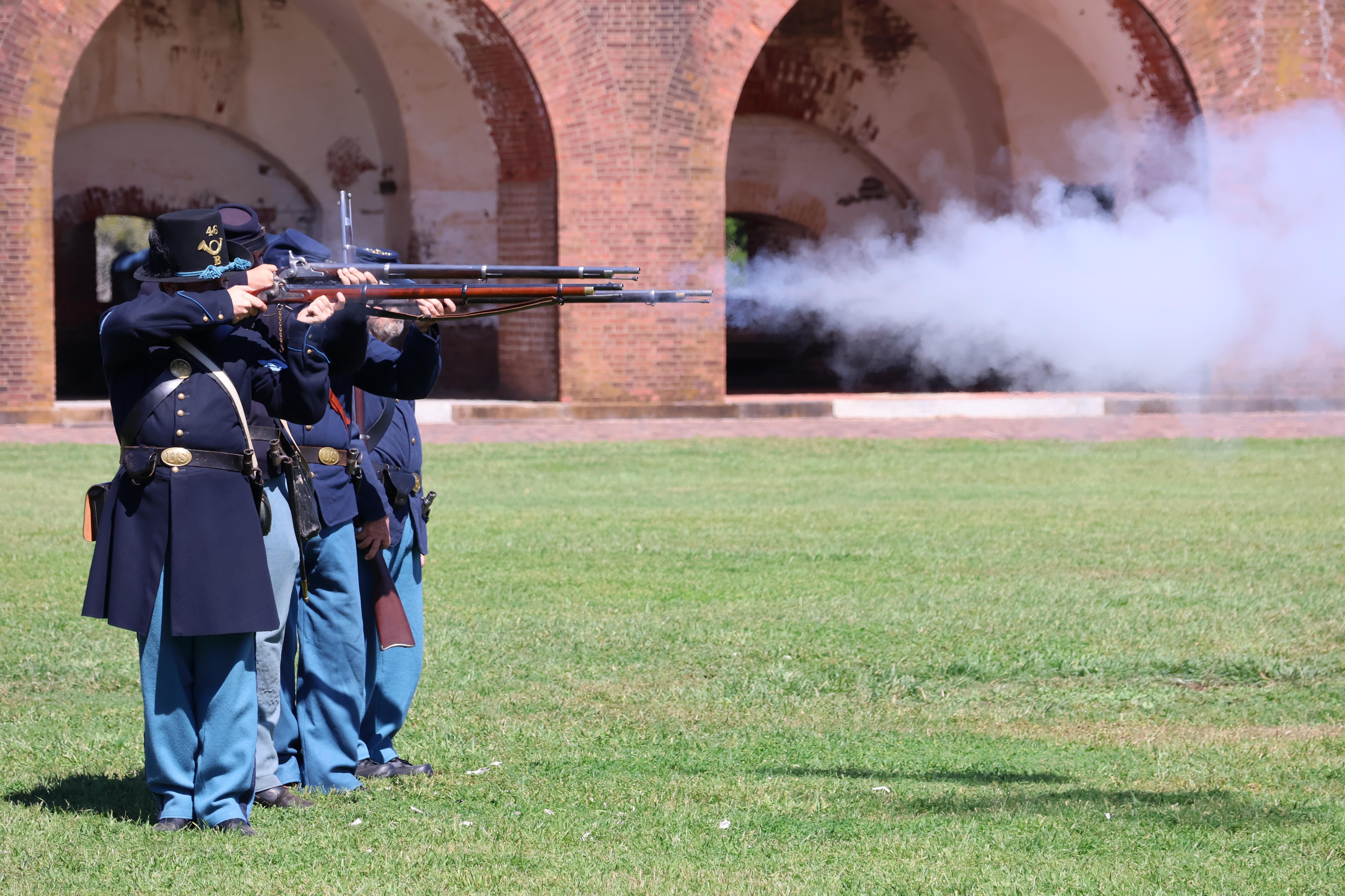 A line of soldiers firing muskets.