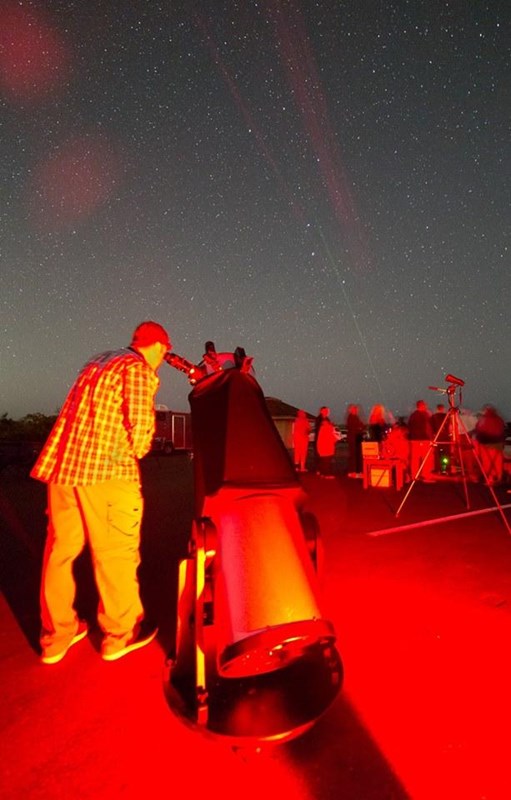A visitor looks through a telescope.