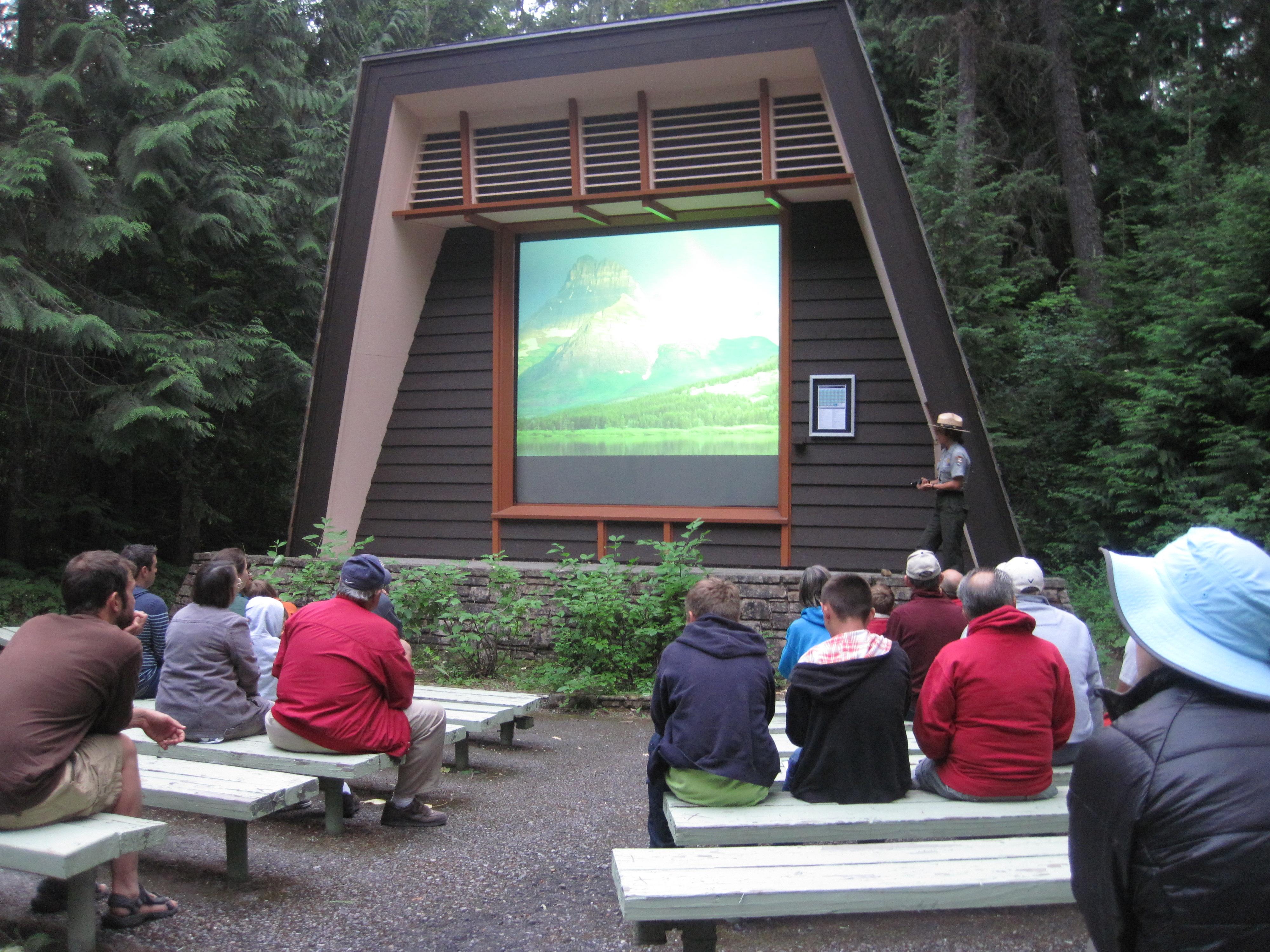 A park ranger stands on stage in front of an audience
