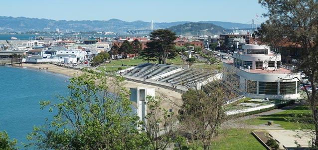 A view looking down on a beach, large building, and bleachers. A view looking down on a beach, large building, and bleachers.