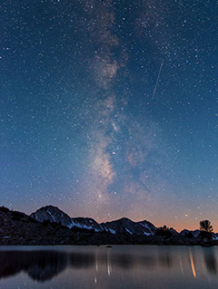 The Milky Way stretches from peaks along the horizon up into the sky The Milky Way stretches from peaks along the horizon up into the sky