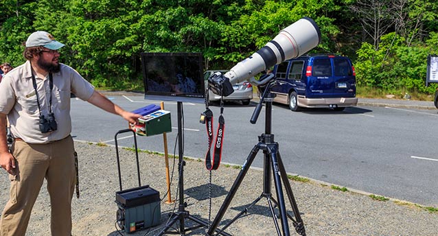A volunteer helps point out a Peregrine falcon nest with the help of a long lens and TV. A volunteer helps point out a Peregrine falcon nest with the help of a long lens and TV.