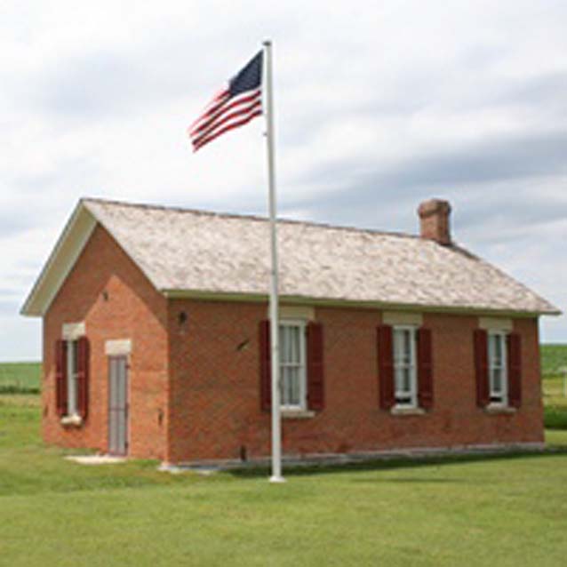 An American flag flies in front of the Freeman One-Room School. An American flag flies in front of the Freeman One-Room School.