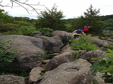 A family hikes through rocks along the trail A family hikes through rocks along the trail