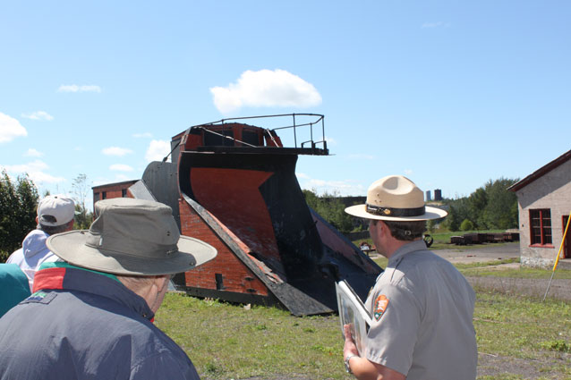 A Park Ranger in front of a locomotive snowplow A Park Ranger in front of a locomotive snowplow