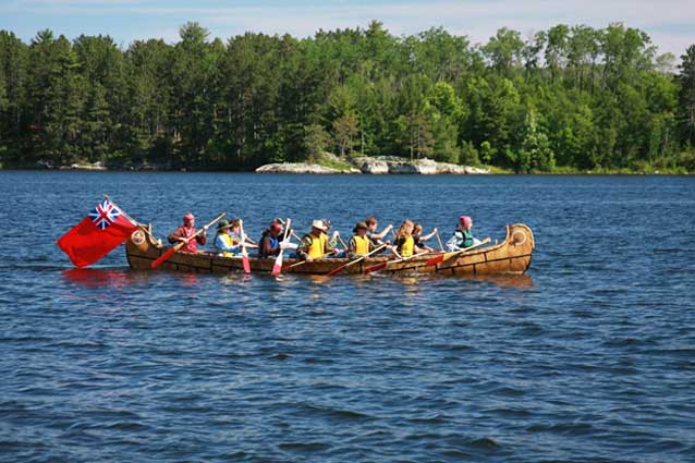 People paddling a replica North Canoe. People paddling a replica North Canoe.