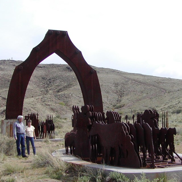 imagen de una escultura de metal que parece un arco con caballos 