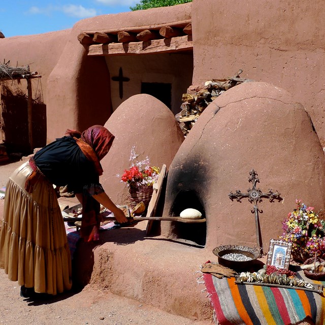 woman working with a stone oven 