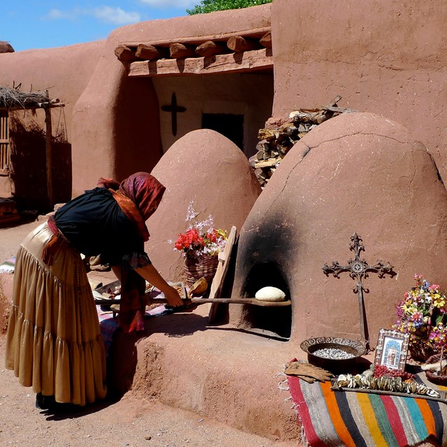 mujer usando horno viejo de piedra 